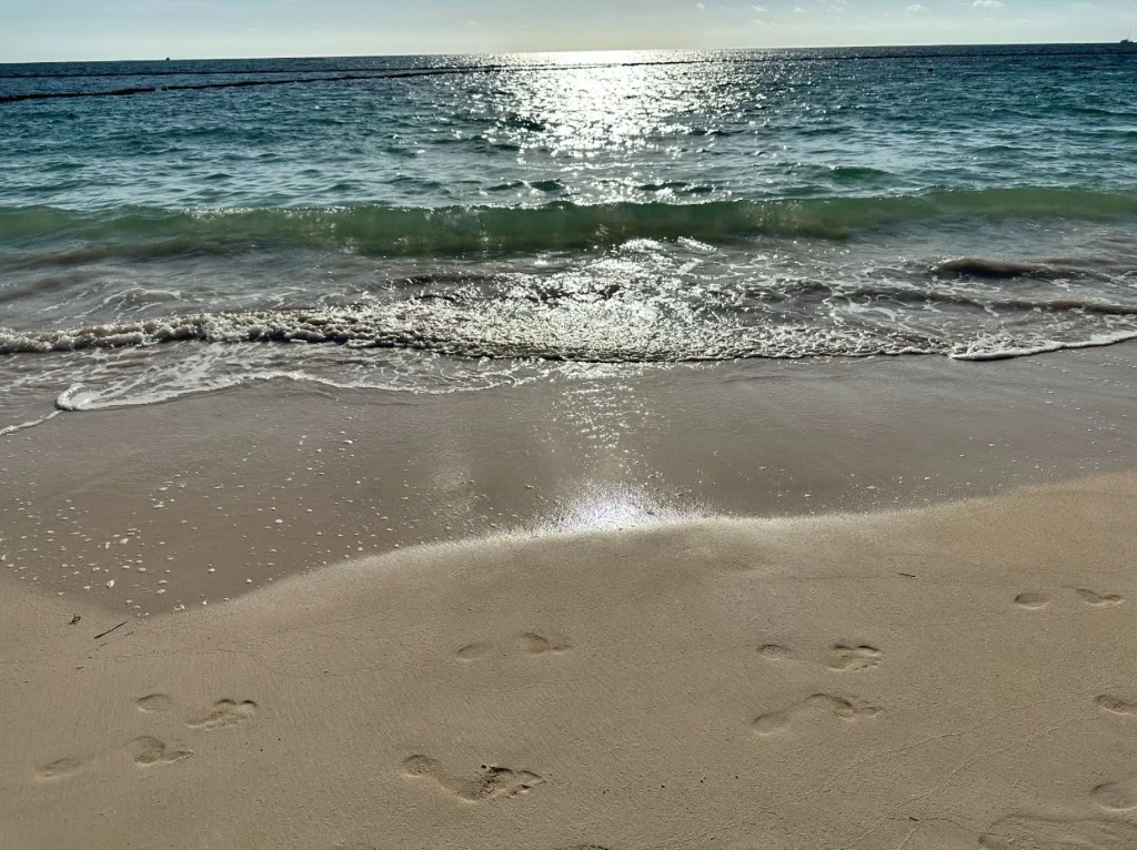 Sunrise reflecting on the waves and footprints at Bávaro Beach