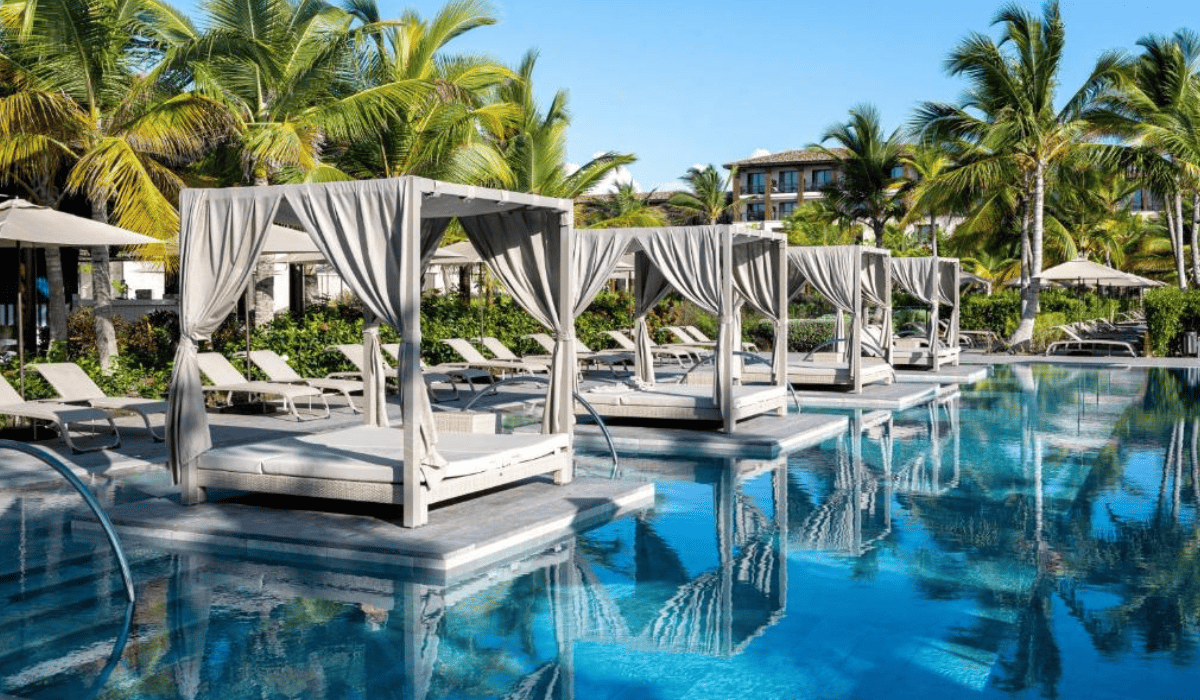 Pool with relaxing loungers and reclining seats in Lopesan Costa B\u00e1varo Resort, Spa & Casino Punta Cana