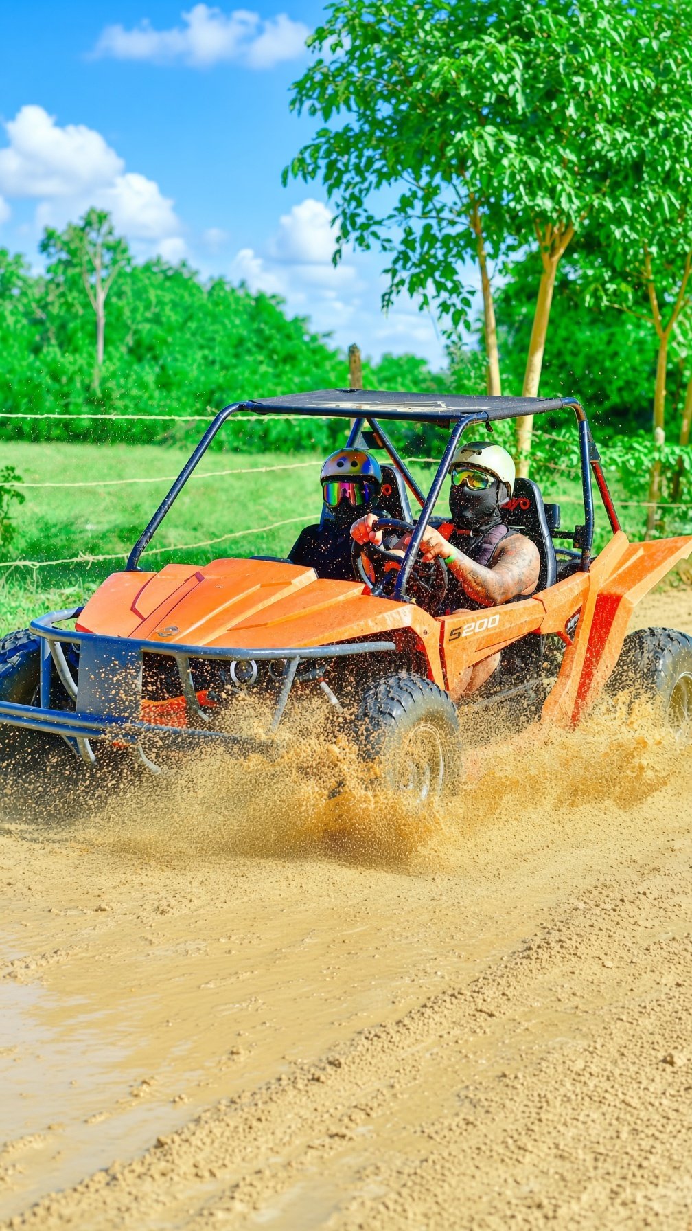 Off-road 4x4 buggy splashing through mud on a countryside trail near Punta Cana